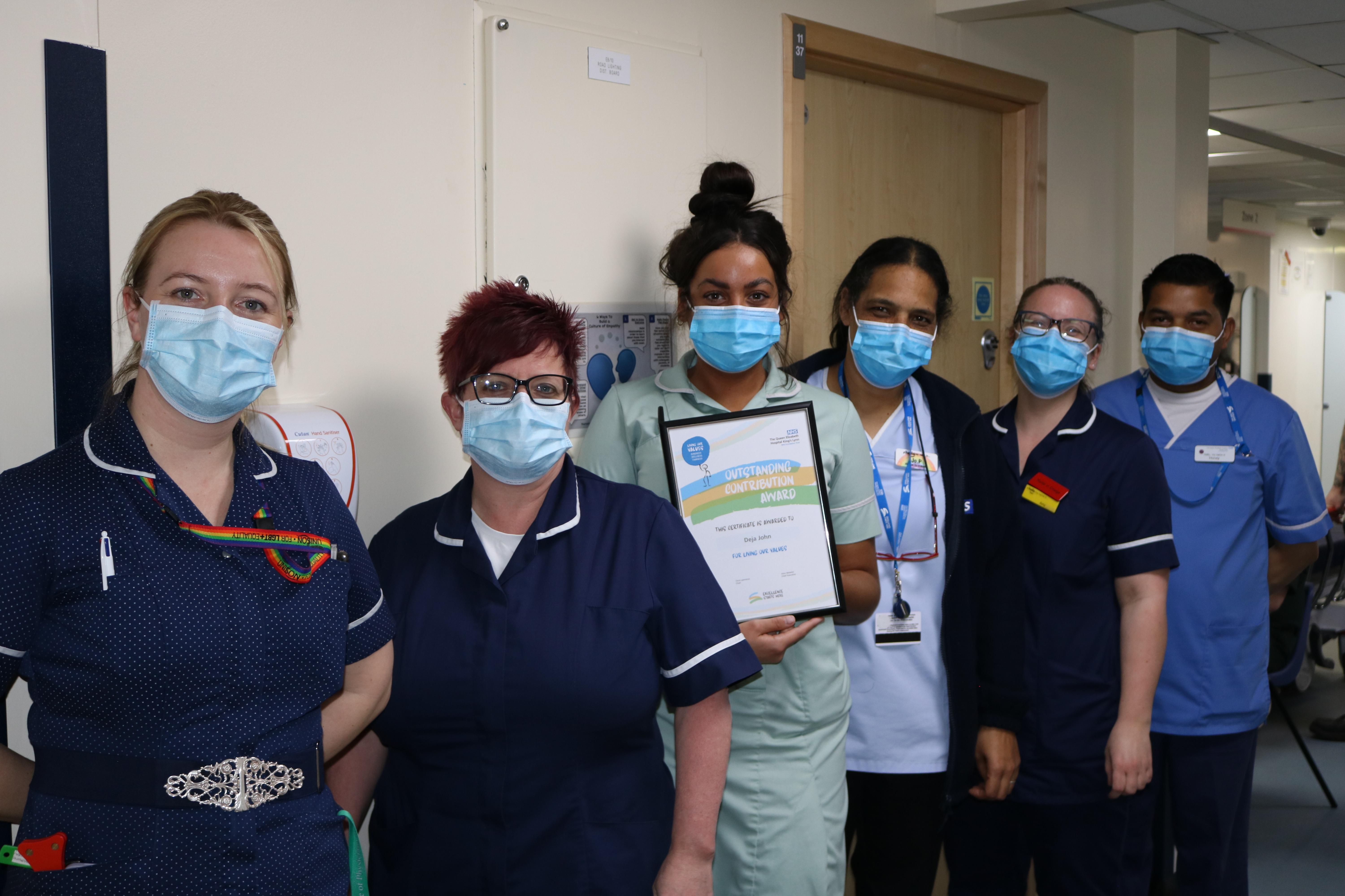 Picture of Deja John and her A&E Colleagues receiving her Living Our Values Award